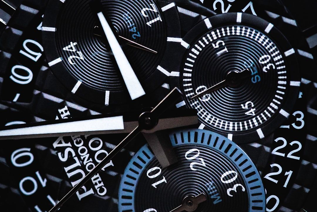 Nahaufnahme eines schwarzen Chronographen-Zifferblatts mit mehreren Hilfszifferblättern, weißen Ziffern und weißen Zeigern mit blauen Akzenten. Diese Uhr fängt die Präzision ein, die an ein Wunderwerk der Aachener Ingenieurskunst erinnert.