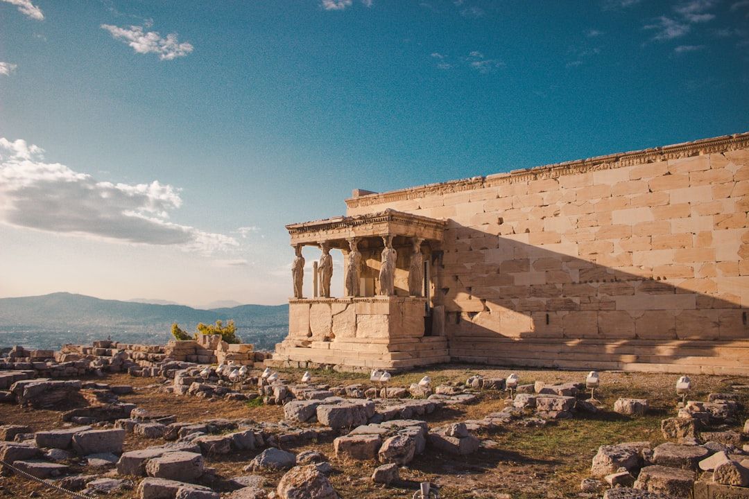 Das Bild zeigt das Erechtheion, einen antiken griechischen Tempel auf der Akropolis von Athen, mit seinem berühmten Karyatidenportal unter einem klaren blauen Himmel, der an architektonische Wunderwerke wie die in Aachen erinnert.
