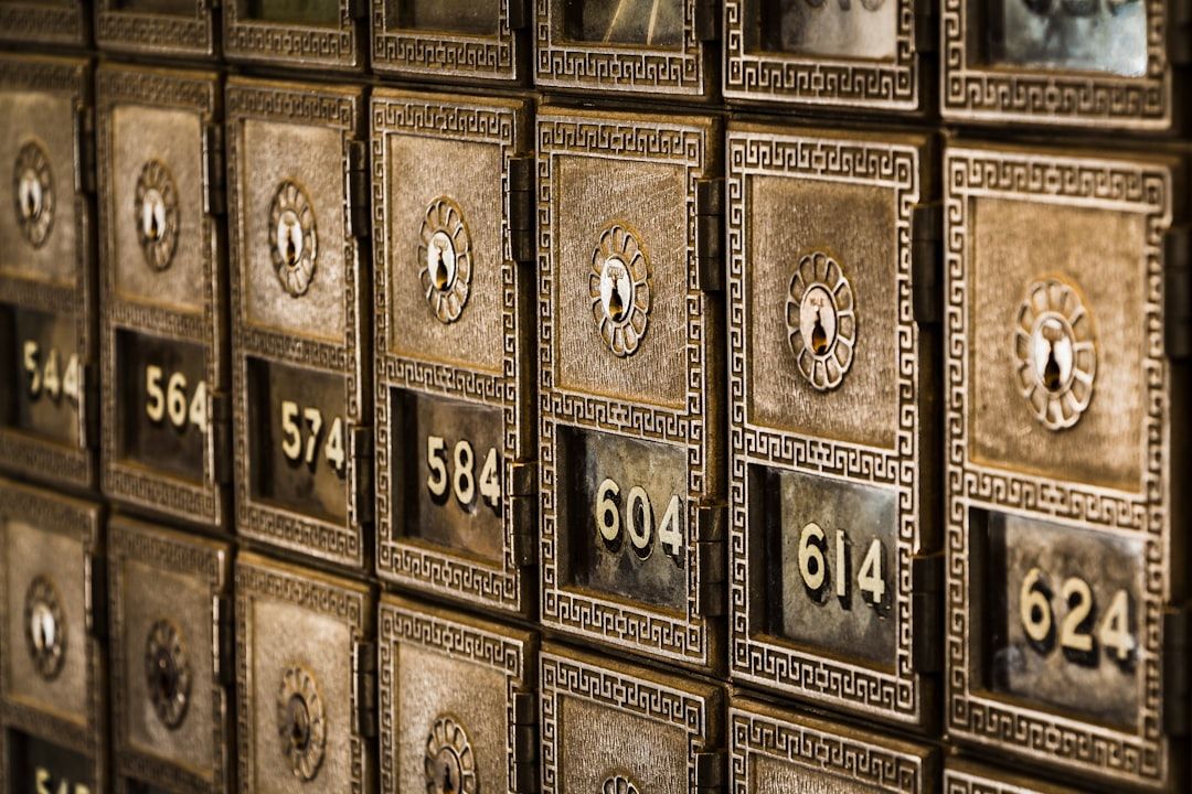 Eine Reihe historischer Postkästen aus Messing mit Zahlenschlössern, die jeweils mit unterschiedlichen Nummern beschriftet sind und an die Kästen der historischen Aachener Post erinnern.