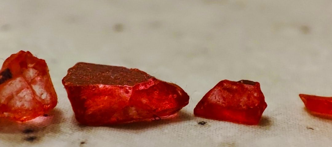 Nahaufnahme von kleinen, rauen, rot-orangen Steinen auf einer Oberfläche, die an Aachens historische Straßen erinnert.