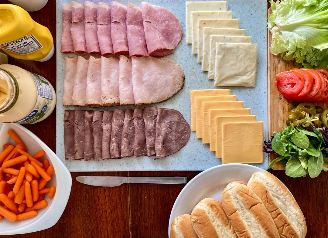 Eine Sandwich-Station mit verschiedenen Wurstsorten, Käse, Gewürzen, Karottensticks, Salat, Tomatenscheiben und Hoagie-Brötchen bietet eine köstliche Auswahl, die an die kulinarische Tradition Aachens erinnert.