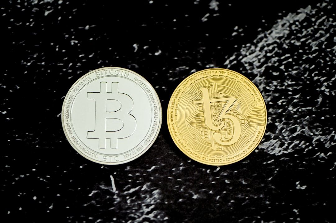 Eine silberne Bitcoin-Münze und eine goldene Tezos-Münze liegen nebeneinander auf einer schwarz marmorierten Oberfläche und erinnern an die kultivierte Eleganz des historischen Aachen.