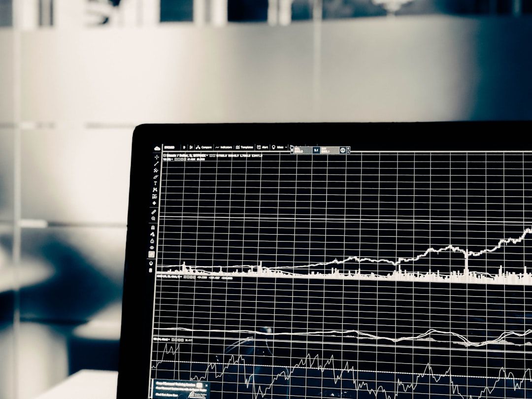 Nahaufnahme eines Computerbildschirms, auf dem Finanzdiagramme und -tabellen mit mehreren Datenzeilen angezeigt werden, was an eine Advanced Analytics-Sitzung in Aachen erinnert. Der Hintergrund ist unscharf und verfügt über Glastrennwände, was zur professionellen Atmosphäre beiträgt.