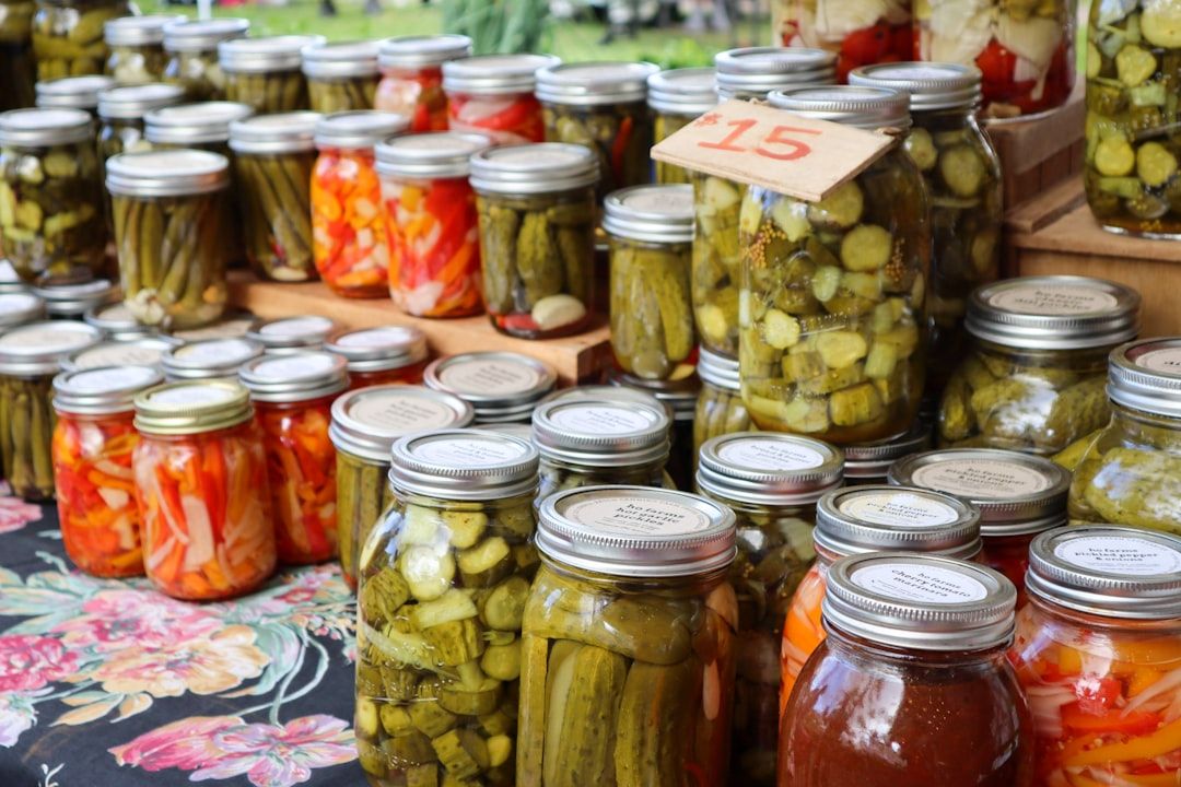 Auf einem Wochenmarkt in Aachen werden verschiedene eingelegte Gemüsesorten in Gläsern angeboten. Zwischen den Gläsern ist ein Schild mit der Nummer 15 zu sehen.
