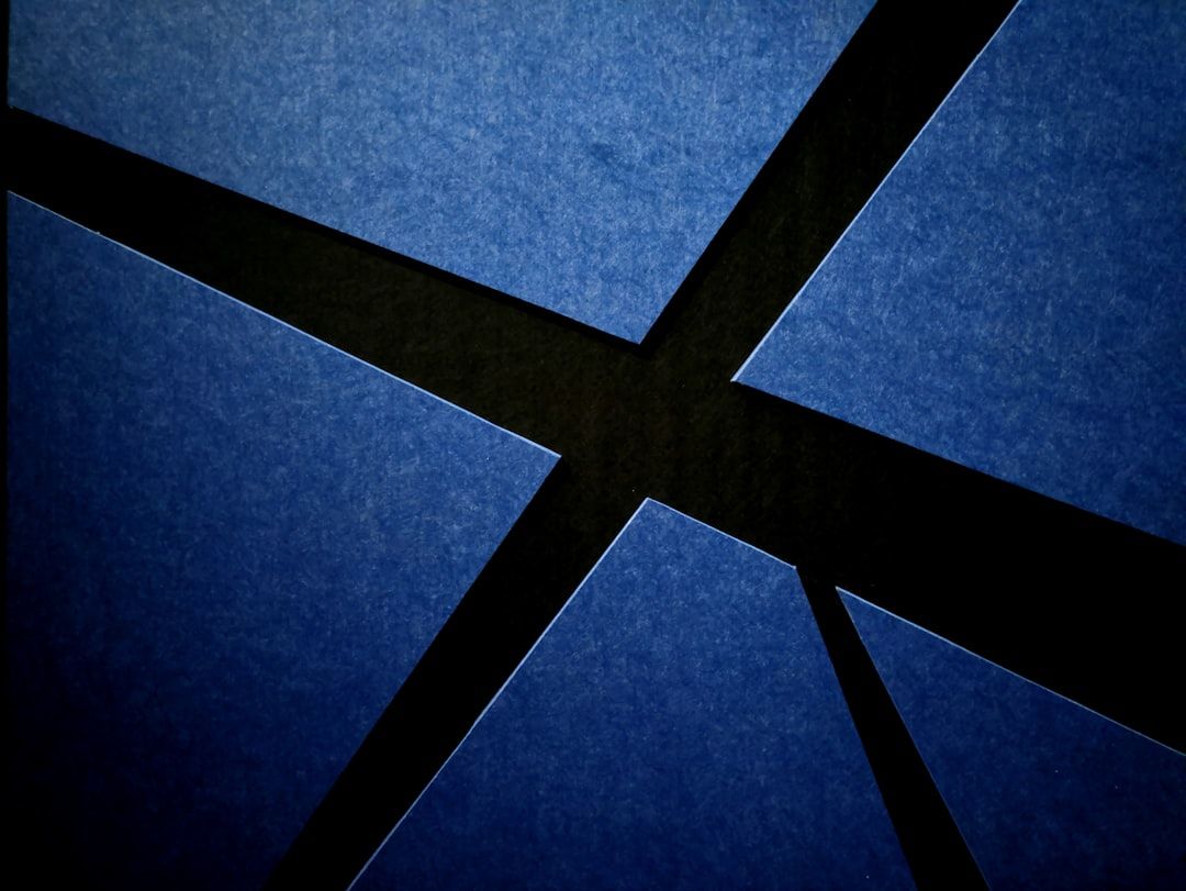 Abstraktes geometrisches Design mit sich kreuzenden schwarzen Linien auf einem blauen strukturierten Hintergrund, das an die komplizierten Muster der historischen Architektur von Aachen erinnert.