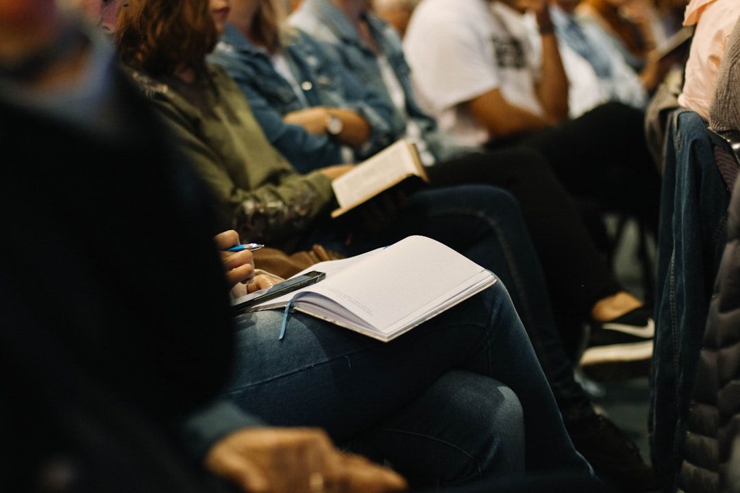 Eng beieinander sitzen Menschen in Aachen, in den Händen Notizblock und Stift, vermutlich besuchen sie eine Vorlesung oder ein Seminar.