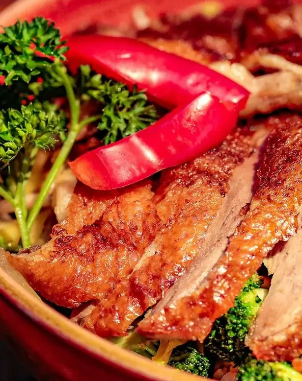 Knusprige Entenscheiben mit Paprika und Kräutern angerichtet