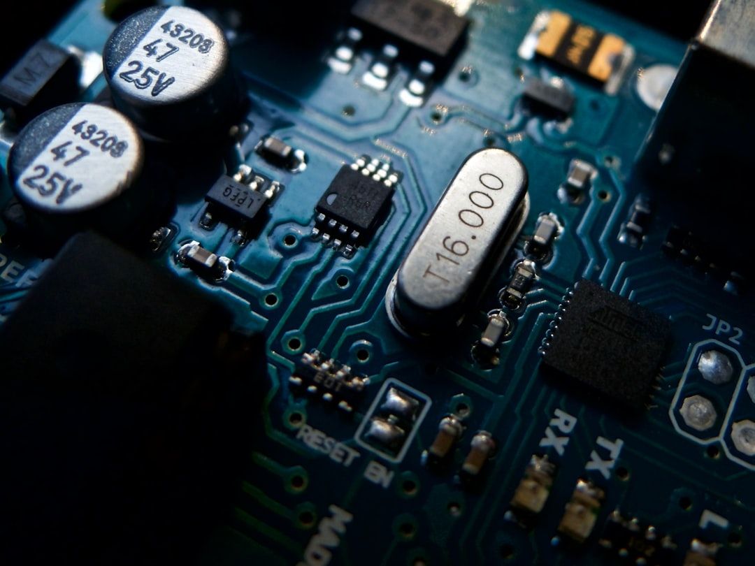 Nahaufnahme einer blauen Leiterplatte mit verschiedenen elektronischen Komponenten, darunter Kondensatoren, Widerstände und ein Quarzoszillator, die an die innovativen Designs der Aachener Technologiezentren erinnert.