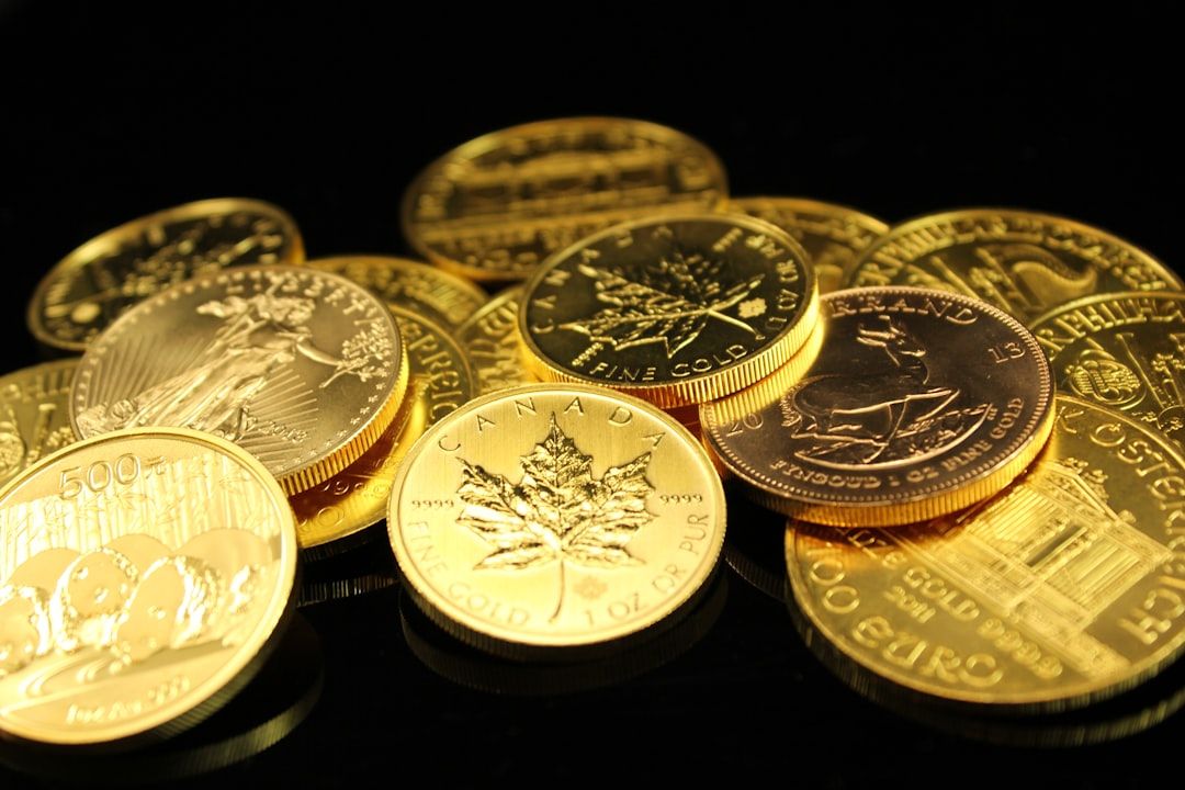 Eine Sammlung verschiedener Goldmünzen, darunter ein kanadisches Maple Leaf und weitere mit unterschiedlichen Motiven, präsentiert auf einem dunklen Untergrund, der an Schätze aus Aachen erinnert.