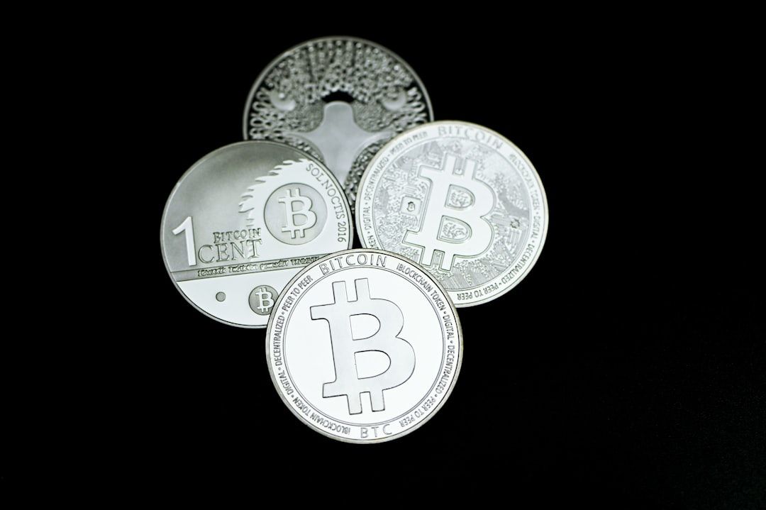 Fünf silberfarbene Münzen mit dem Bitcoin-Symbol auf schwarzem Hintergrund, die an den historischen Charme Aachens erinnern.