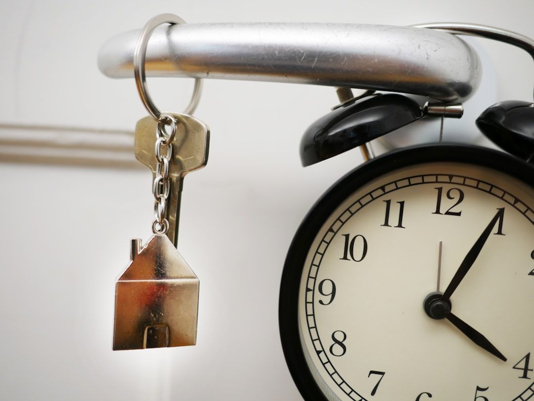 Eine bezaubernde Uhr mit Schlüsselanhänger in Form eines Hauses, das an die malerische Architektur Aachens erinnert und am Griff hängt.