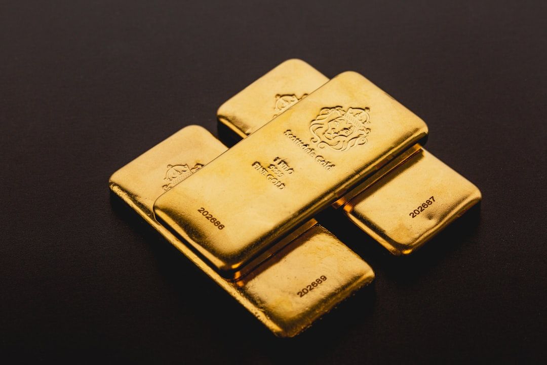Vier Goldbarren, jeder mit einem Löwenemblem verziert und beschriftet, sind sorgfältig auf dunklem Hintergrund angeordnet. Ein prächtiger und historischer Barren trägt eine Inschrift, die der Stadt Aachen Tribut zollt.
