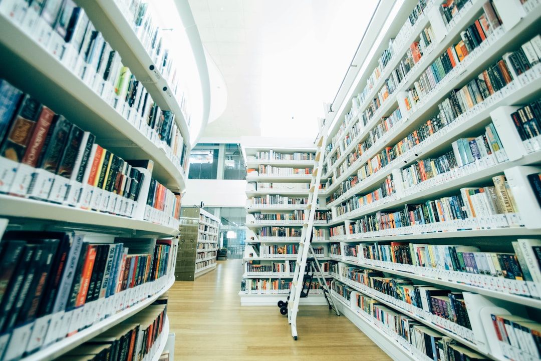 Ein hell erleuchteter Gang einer Aachener Bibliothek, auf beiden Seiten mit Bücherregalen gefüllt, in der Mitte steht eine Rollleiter.