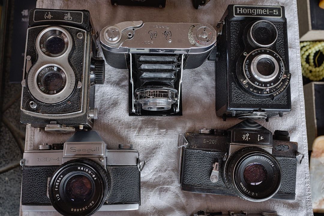 Eine Sammlung von Vintage-Kameras aus Aachen, darunter Modelle wie die Seagull, Hongmei-5 und andere, präsentiert auf einer strukturierten Oberfläche.