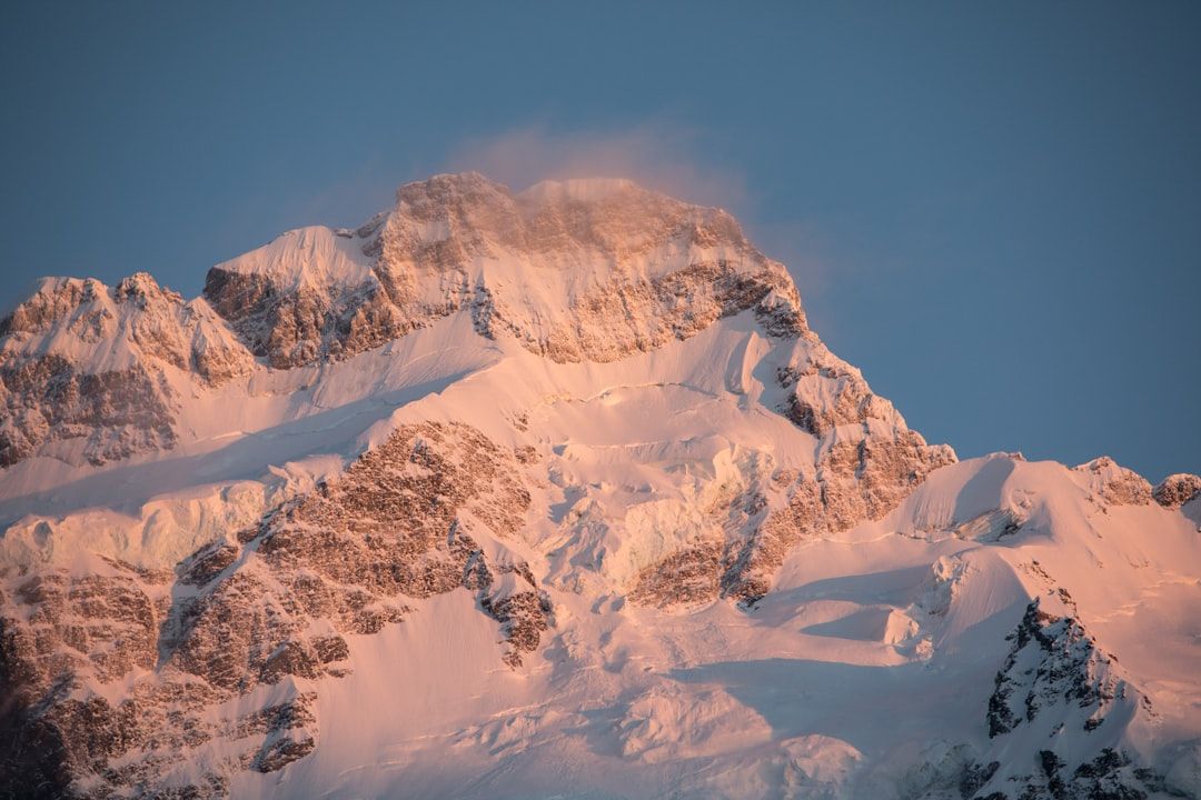 Schneebedeckter Berggipfel im Sonnenaufgang mit klarem Himmel im Hintergrund, erinnert an die ruhigen Landschaften bei Aachen.