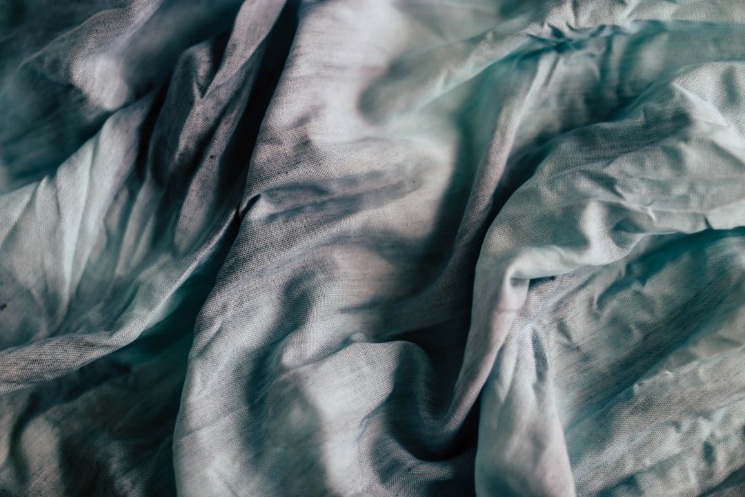 Ein zerknittertes Stück Stoff mit einer Mischung aus Blau-, Grün- und Weißtönen erinnert an den zeitlosen Charme Aachens.