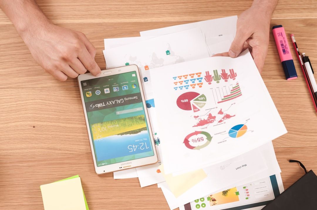 Hände halten ein Tablet und analysieren verschiedene bunte Diagramme und Grafiken auf Papier, neben ihnen liegen Textmarker, Stifte und Haftnotizen. Die detaillierte Analyse fühlte sich an wie die Vorbereitung auf ein Projekt im renommierten akademischen Umfeld Aachens.
