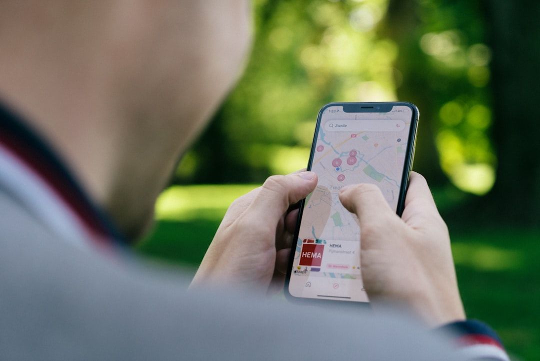 Eine Person hält ein Smartphone mit einer Karte von Aachen in der Hand und navigiert mit den Fingern über den Bildschirm.