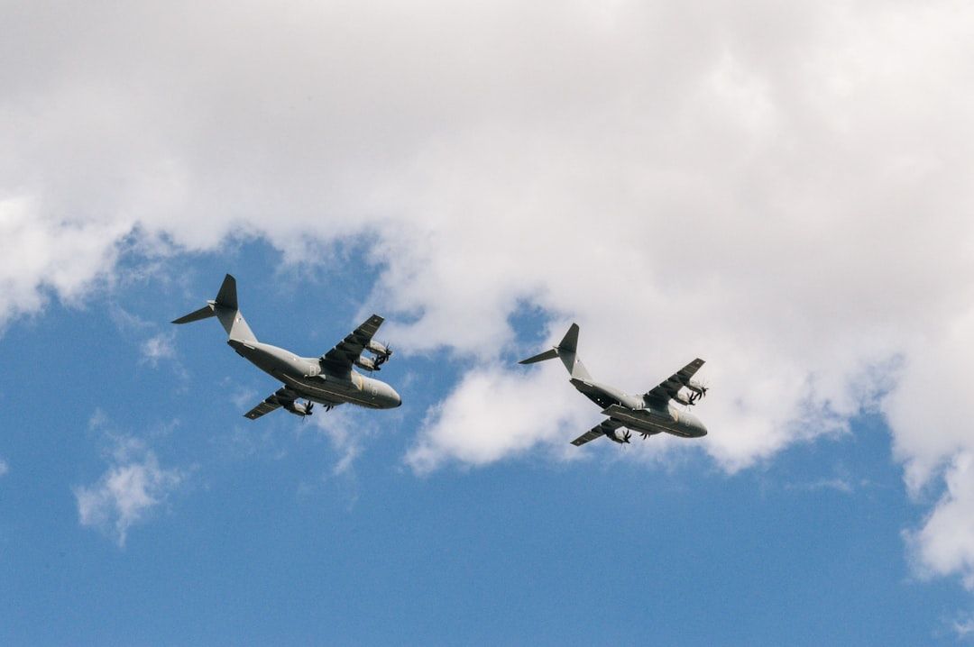 Zwei Militärtransportflugzeuge schweben über Aachen und navigieren ihren Weg durch die lockeren Wolken.