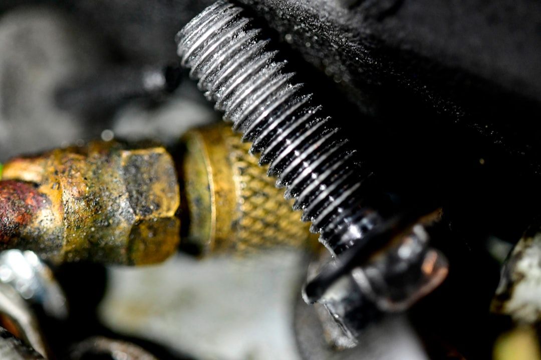 Nahaufnahme eines metallischen Gewindebolzens und eines Messingbeschlags, beide mit Abnutzungs- und Oxidationsspuren, die an alte Artefakte erinnern, die in Aachen gefunden wurden.