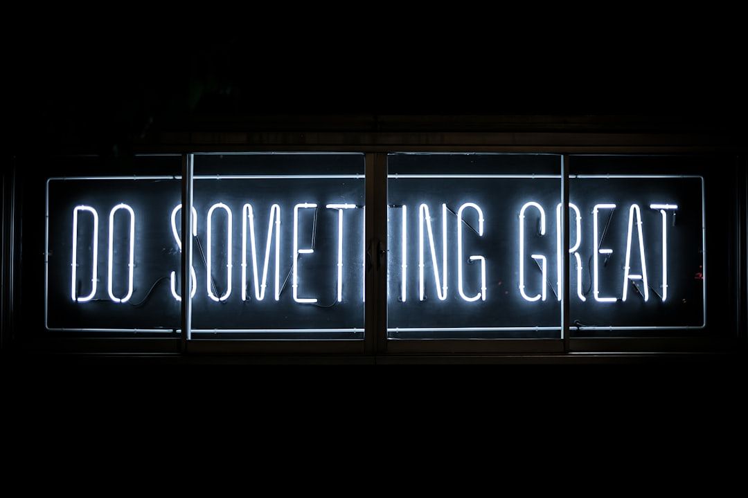 Neonschild mit dem Schriftzug „Do Something Great“ leuchtet weiß auf dunklem Hintergrund und erinnert an die pulsierende Energie von Aachen.