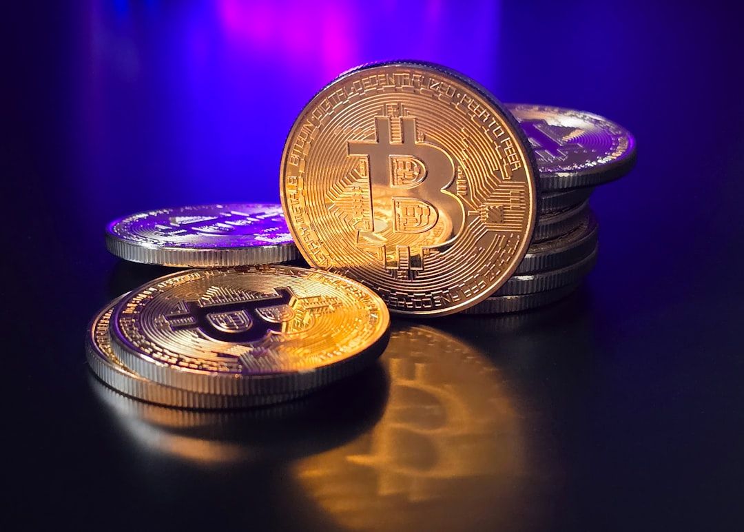 Mehrere goldene Bitcoin-Münzen sind auf einer glänzenden Oberfläche vor einem leuchtend blau-violetten Hintergrund mit Farbverlauf gestapelt und verstreut, was an die Mischung aus Aachens reicher Geschichte und moderner Technologie erinnert.