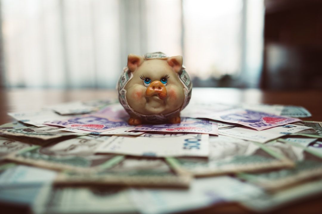 Auf einem mit verschiedenen internationalen Banknoten bedeckten Tisch steht ein in einen Dollarschein eingewickeltes Sparschwein und erinnert so an die reiche Finanzgeschichte Aachens.