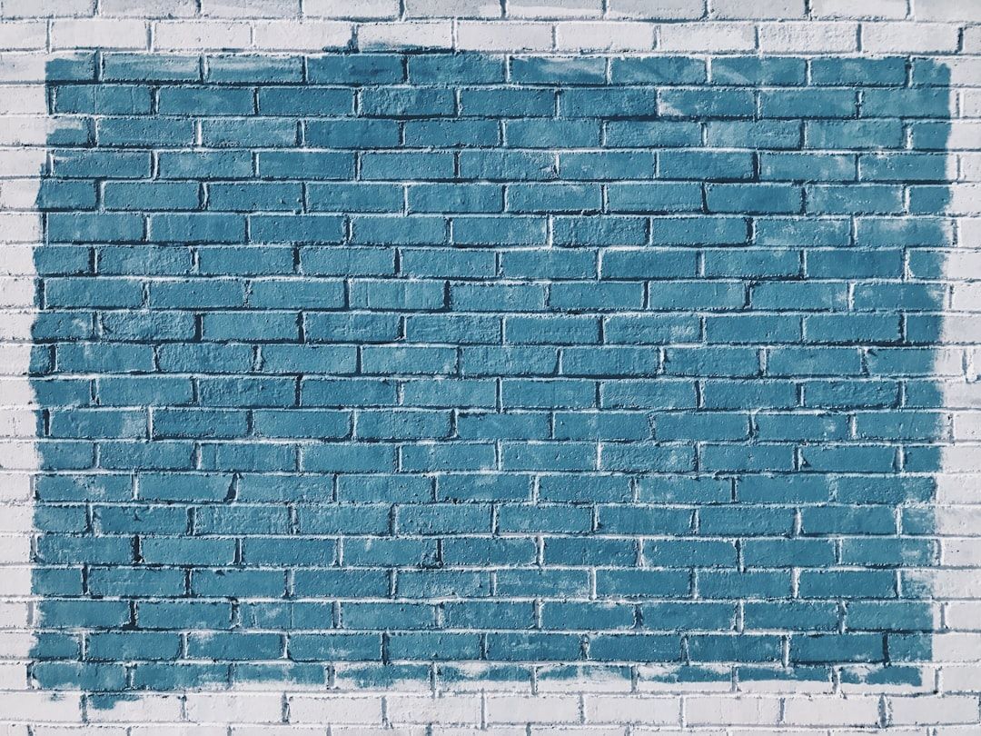 Eine weiße Backsteinmauer mit einem in der Mitte blau gestrichenen Rechteckabschnitt, der an die modernen Architekturstile Aachens erinnert.