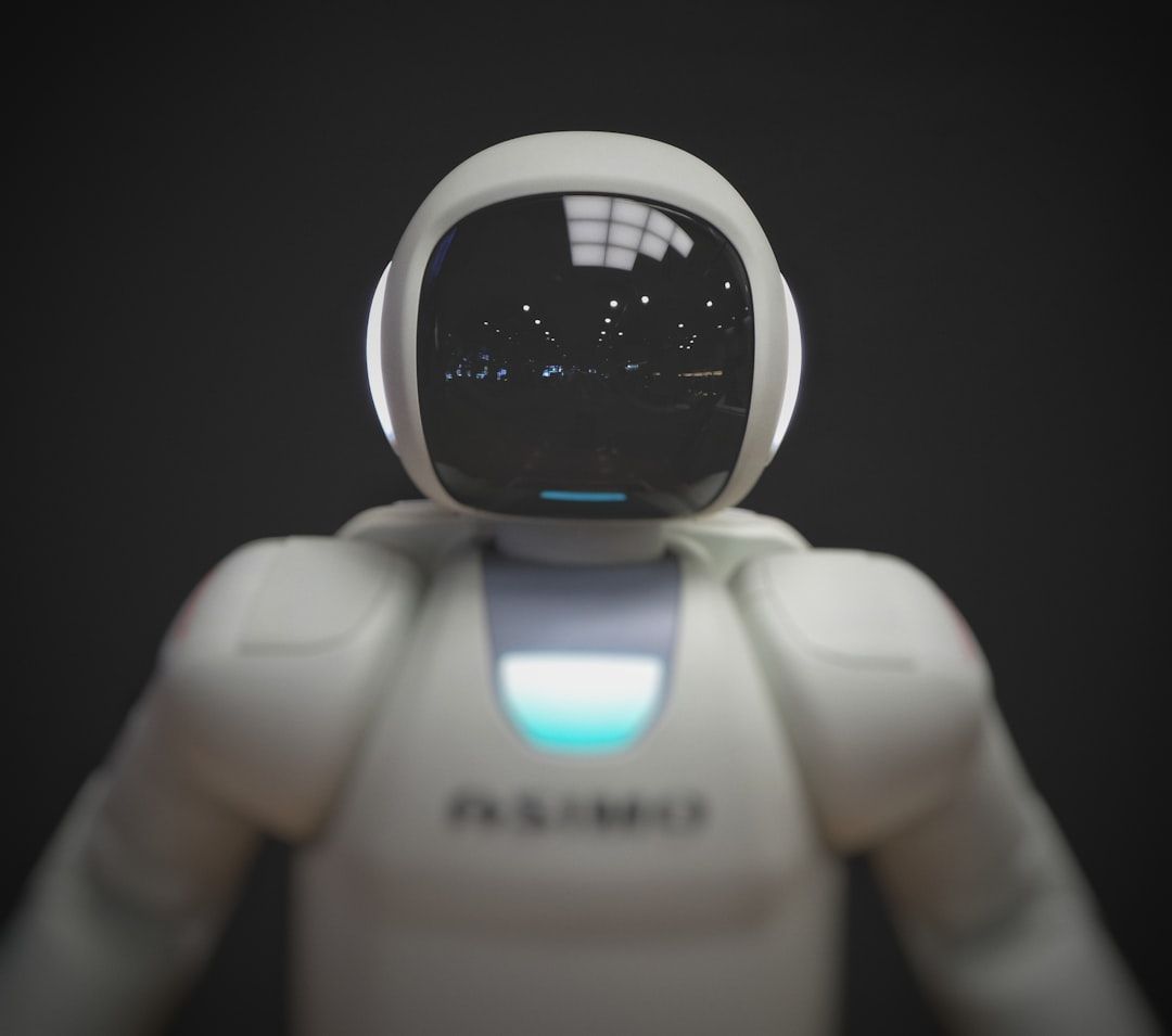 Ein humanoider Roboter in elegantem weißen Design steht vor einem dunklen Hintergrund, sein glänzendes schwarzes Visier reflektiert das Licht. Dieses Wunderwerk der Technik erinnert an die bahnbrechenden Innovationen, die in Aachens technologischem Fortschritt zu finden sind.