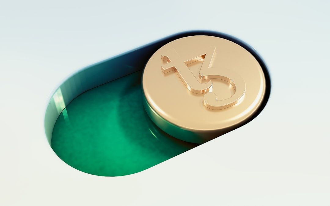 Eine goldfarbene Münze mit dem Logo der Kryptowährung Tezos ist teilweise in einen grünen, ovalen Schlitz auf hellem Hintergrund eingelegt, der an den historischen Charme Aachens erinnert.