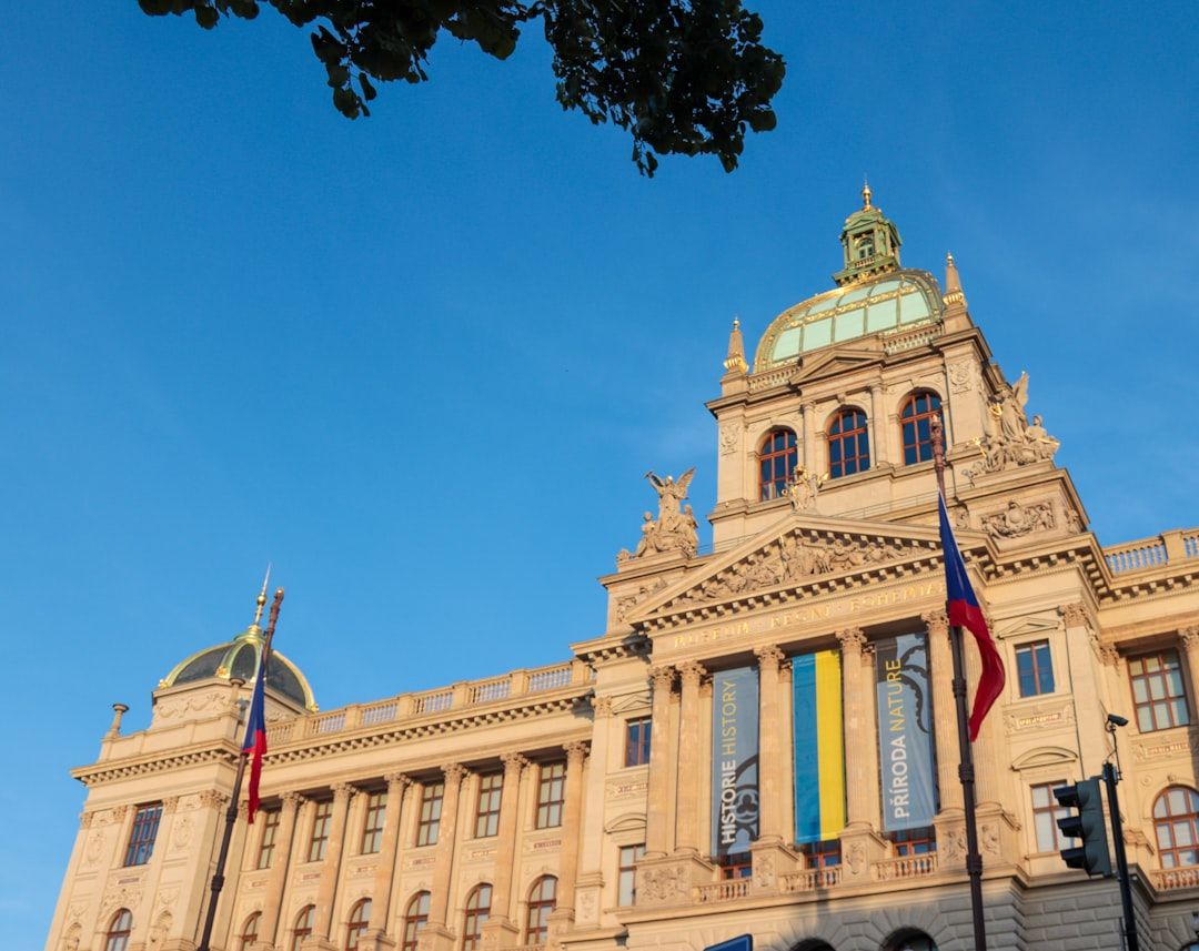 Ein historisches Gebäude in Aachen mit einer großen Kuppel, aufwändiger Architektur und Flaggen. Unter einem klaren blauen Himmel hängen Banner mit den Aufschriften „Geschichte“ und „Natur“.