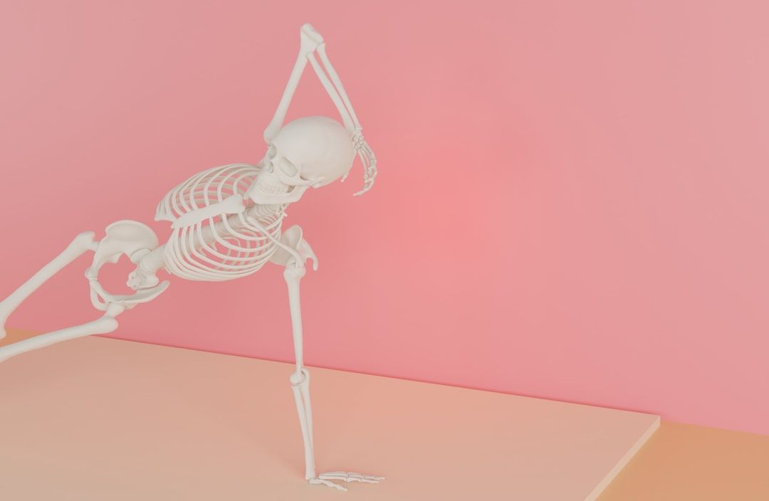 Ein weißes Skelett in der seitlichen Plank-Yoga-Pose vor einem rosa Hintergrund, das an das künstlerische Flair von Aachen erinnert.