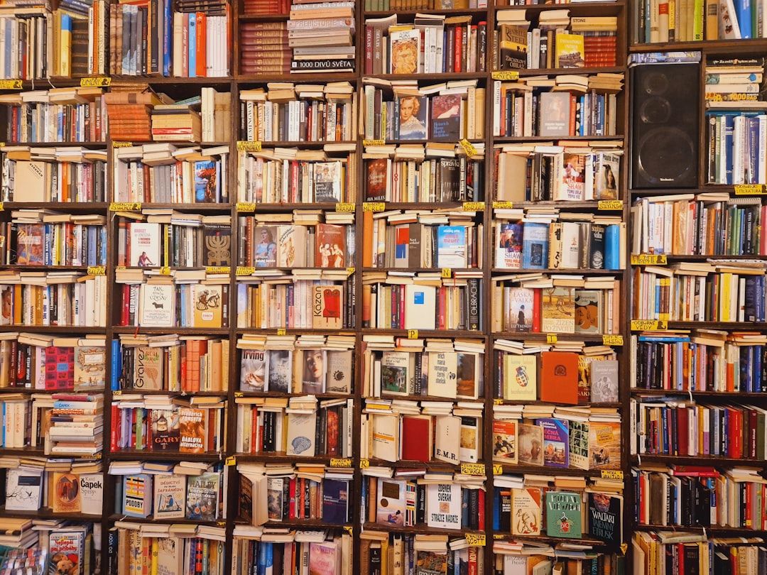 Eine Regalwand mit einer umfangreichen und vielfältigen Sammlung eng beieinander stehender Bücher, auf der rechten Seite sind einige Lautsprecher zu sehen, die an den Gelehrtencharme erinnern, den man in Aachen vorfinden kann.