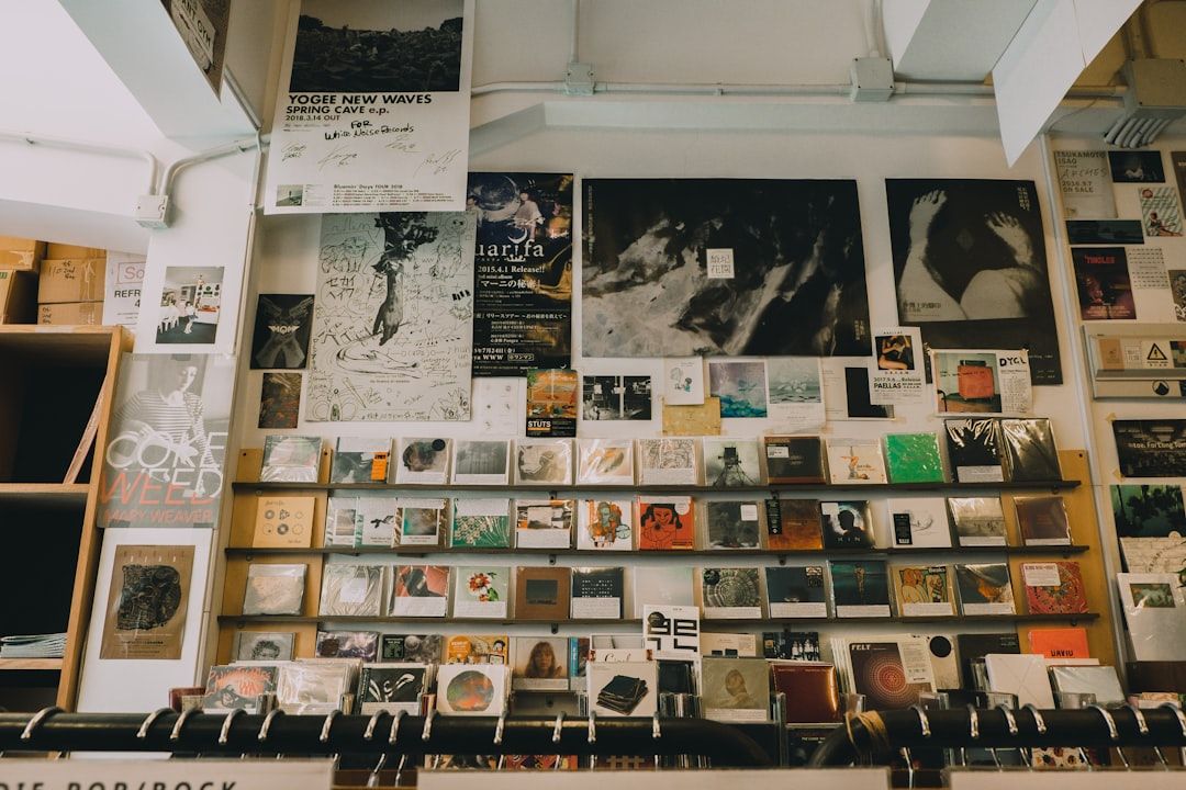 In einem Aachener Musikgeschäft ist eine Wand mit verschiedenen Postern, Schallplatten und CDs geschmackvoll in Szene gesetzt.