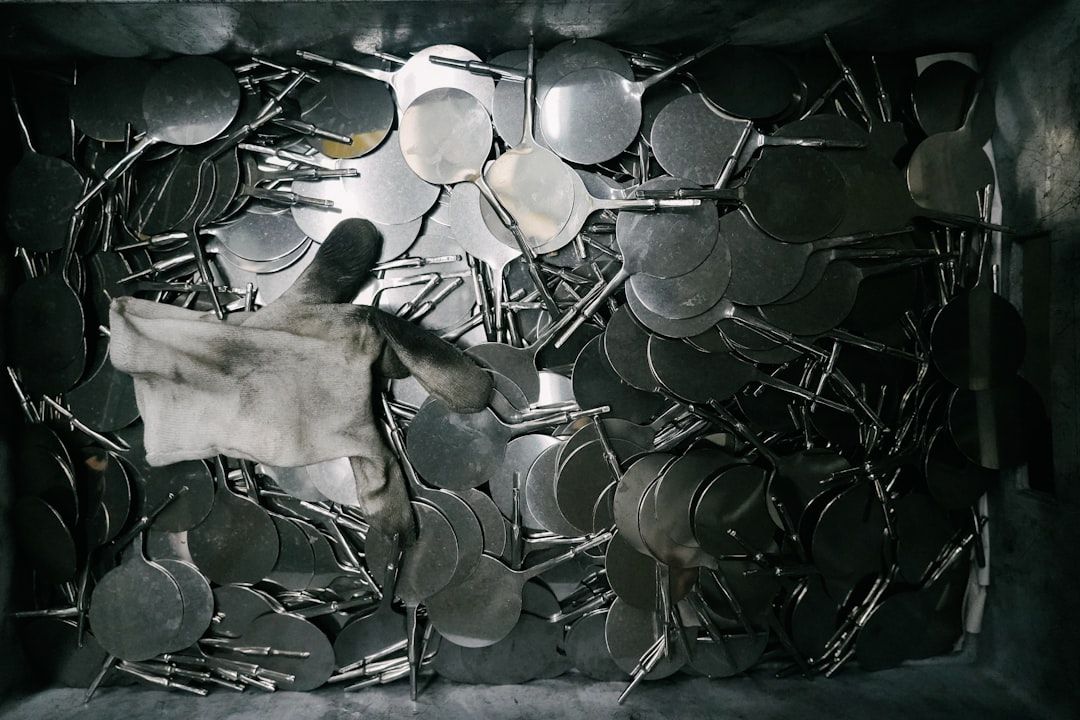 Ein schmutziger Handschuh liegt auf einem Stapel spitzer Metallscheiben in einem Container und erinnert an Relikte aus der Aachener Industriegeschichte.